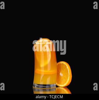 Frische organische Orangensaft und Wodka in ein hohes Glas auf schwarzem Hintergrund Stockfoto