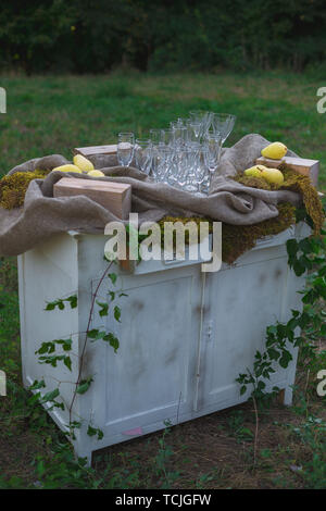 Hochzeit Dekor. Hochzeit auf einem Teller grün hinterlegt und die Berge. Hochzeit Dekorationen, Birnen und Moos. Schattierungen von Grün und Gelb Stockfoto
