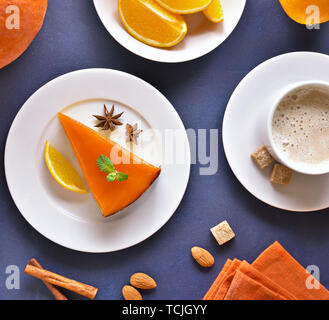 Stück Pumpkin Pie und Tasse Kaffee auf blauen Stein Hintergrund. Ansicht von oben, flach Stockfoto