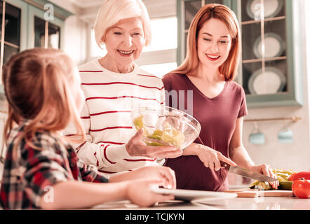 Gerne ältere Frau Vorbereitung Abendessen für ihre Familie Stockfoto