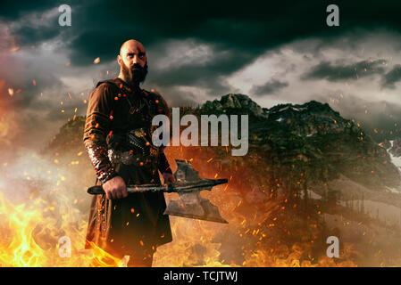 Zornige Wikinger mit Axt, Kampf in Rocky Mountains Stockfoto