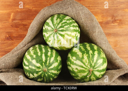 Reife Wassermelonen in Säcken auf hölzernen Hintergrund close-up Stockfoto