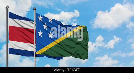 Costa Rica und Solomon Inseln Flagge im Wind gegen Weiße bewölkt blauer Himmel zusammen. Diplomatie Konzept, internationale Beziehungen. Stockfoto