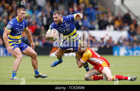 Warrington Wolves' Daryl Clark wird durch die Katalanen Drachen' Sam Tomkins in Angriff genommen, während die Betfred Super League match Am Halliwell Jones Stadium, Warrington. Stockfoto