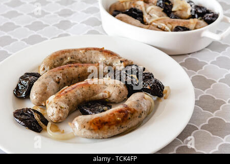 Weiße Wurst gebraten mit Zwiebeln und getrocknete Pflaumen. Stockfoto