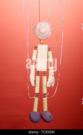 Hölzerne Marionette auf rotem Hintergrund Stockfoto