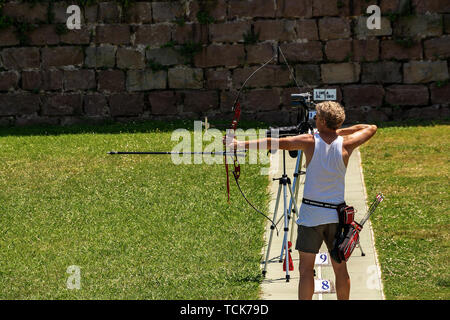 BARCELONA, SPANIEN - 11. JUNI 2014: Ein erwachsener Mann ist die Ausbildung im Bogenschießen mit einem olympischen Recurve Bogen neben dem Schloss, Barcelona Montjuic Hügel Stockfoto