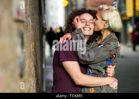 Junge Frau küssen ihren Freund im städtischen Hintergrund auf einem typischen Londoner Straße Stockfoto