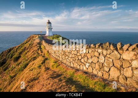 Weg mit Steinmauer führt zum Leuchtturm am Cape Reinga, weit North District, Northland, North Island, Neuseeland Stockfoto