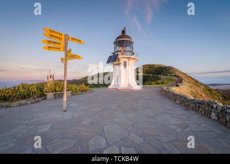 Internationale Wegweiser auf dem Leuchtturm am Cape Reinga in Abendstimmung, weit North District, Northland, North Island, Neuseeland Stockfoto