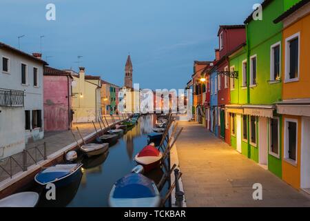 Günstig chartern Boote auf dem Kanal mit bunten Häusern, hinter San Martino Kirche in der Dämmerung, Insel Burano, Lagune von Venedig, Venedig, Venetien, Italien Stockfoto