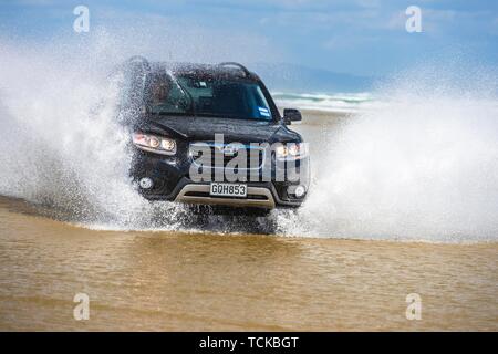 Schwarz Hyundai Santa Fe 4x4 SUV Antriebe am Strand von Ninety Mile Beach im Wasser, weit im Norden Bezirk, Northland, North Island, Neuseeland Stockfoto