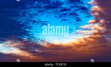 Panorama defokussierten Ansicht einer weiten blauen Himmel mit Puffy dunkle Wolken bei Sonnenuntergang gefüllt Stockfoto