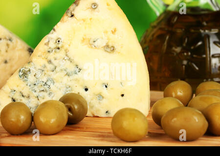 Zusammensetzung des blauen Käse und Oliven auf hellen grünen Hintergrund close-up Stockfoto