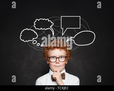 Denken Kind Junge und leere Rede wolken Blasen auf schiefertafel Hintergrund. Nachdenkliches Kind in Gläsern auf Schule Blackboard Stockfoto