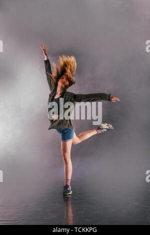 Tänzerin zeigt ihre Eleganz, indem sie ihr Bein hoch über den Kopf. Stockfoto