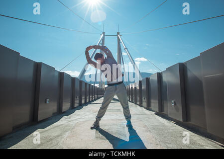 Ein Mann ist, genießen Sie die frische Luft beim Trainieren auf der Brücke Stockfoto