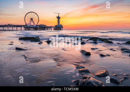 Sonnenuntergang an der Küste, Strand, Pier und Riesenrad, Scheveningen, Den Haag. Stockfoto