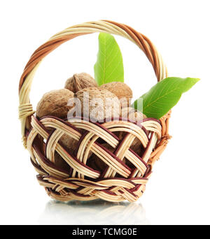 Walnüsse mit grünen Blättern im Korb, isoliert auf weißem Stockfoto