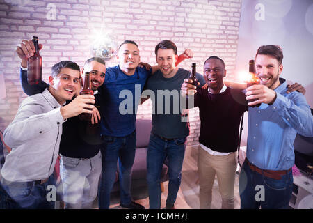 Portrait von Lächelnden jungen Männer mit Flaschenbier in der Kamera im Pub suchen Stockfoto