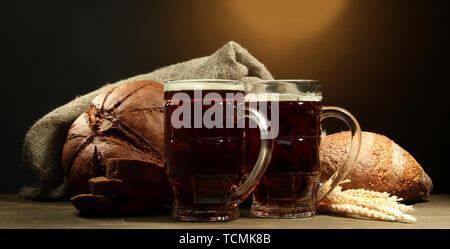 Seidel von Kwass und Roggen Brot mit Ohren, auf Holztisch auf braunem Hintergrund Stockfoto