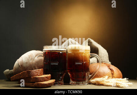 Seidel von Kwass und Roggen Brot mit Ohren, auf Holztisch auf braunem Hintergrund Stockfoto