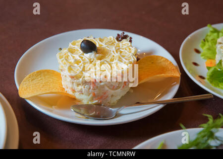 Teil 2-in-1-Salat mit Fisch, Karotten und Eier. Studio Foto. Salat mit gebratenen Kartoffeln Kuchen auf einem weissen Teller, selektive konzentrieren. Kartoffel Mayonnaise sa Stockfoto