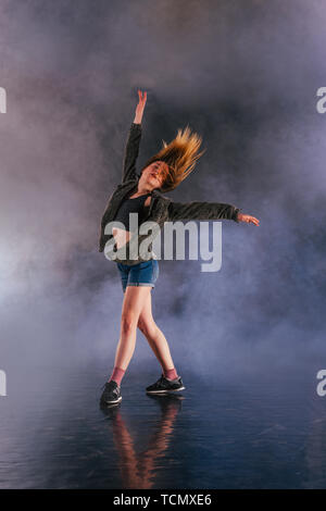 Tänzerin zeigt ihre Eleganz, indem sie ihr Bein hoch über den Kopf. Stockfoto