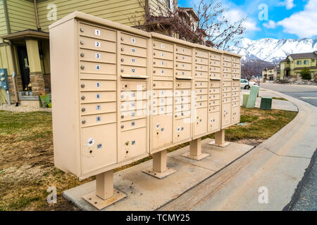 Wohn- Mailboxen mit nummerierten Fächern auf der Seite einer Straße Stockfoto