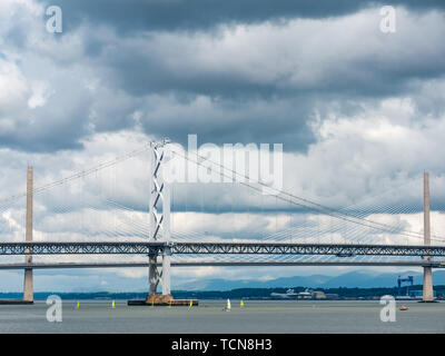 South Queensferry, Schottland, Vereinigtes Königreich, 9. Juni 2019 UK Wetter: Dramatische helle und dunkle Wolken über die Forth Road Bridge und die queensferry Kreuzung mit leuchtend gelben Jollen Erstellen einer krassen Farbe und Größe Kontrast in der Forth River sammeln Stockfoto