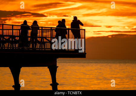 Aberystwyth, Großbritannien. 09. Juni 2019 Deutschland Wetter: Die untergehende Sonne dramatisch leuchtet den Abendhimmel in Aberystwyth, West Wales, am Ende der gemischten Tag der Sonne und heftigen Regenschauern. Nasses Wetter ist weit über die Süd- und die Großbritannien in den nächsten 24 Stunden Prognose mit verstreuten Schwere oder thundery Duschen mit länger andauernder Regen vermischt. Credit: Keith Morris/Alamy leben Nachrichten Stockfoto