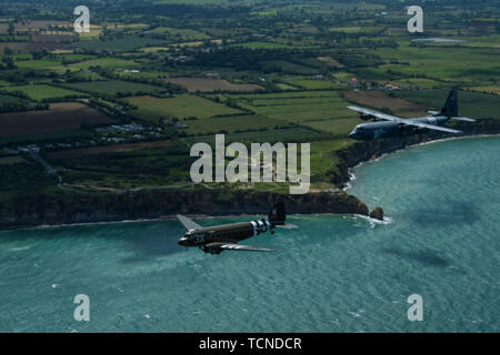 Eine Douglas C-47 Dakota, der den Spitznamen "Das ist Alles, Bruder", Fliegen mit US Air Force C-130J Super Hercules, der 37Th Airlift Squadron, Air Base Ramstein, Deutschland, über Pointe-du-Hoc, Frankreich, 8. Juni 2019 vergeben. Der 37 Truppentransporter Geschwader, das Erbe Geschwader zu der 37. Als, trug die "W7" oder "Whiskey 7"-Markierungen während der Operation Neptune, 6. Juni 1944. "Das ist alles, Bruder" flog während der Invasion in der Normandie. (U.S. Air Force Foto von älteren Flieger Devin M. Rumbaugh) Stockfoto