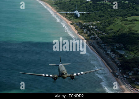 Eine Douglas C-47 Dakota, der den Spitznamen "Das ist Alles, Bruder", Fliegen mit US Air Force C-130J Super Hercules, der 37Th Airlift Squadron, Air Base Ramstein, Deutschland, in der Normandie, Frankreich, 8. Juni 2019 vergeben. Die C-130J trug Invasion Markierungen, ähnlich wie es das Erbe von Squadron, die 37Th Truppentransporter Squadron, die kampfeinsätze während der Operation Neptune, Juni 6, 1944 flog. (U.S. Air Force Foto von älteren Flieger Devin M. Rumbaugh) Stockfoto