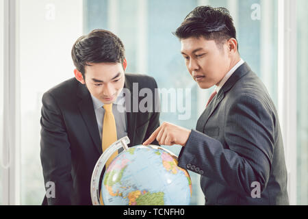 Close-up von zwei junge Unternehmer bei der Globus suchen Stockfoto