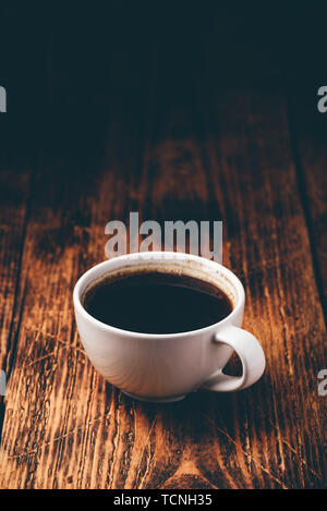 Schwarzen Kaffee in Weiß cup über Holz- Oberfläche Stockfoto