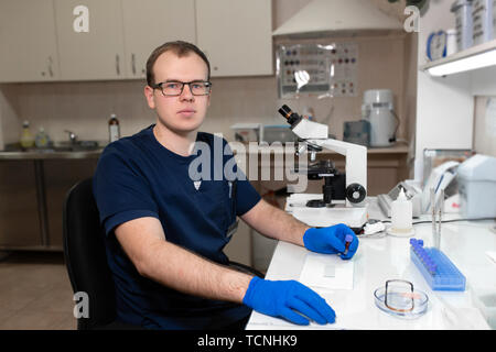 Porträt der jungen kaukasischen männliche Wissenschaftler, medizinische Mitarbeiter, Tech oder graduate student arbeitet in modernen biologischen Labor. Stockfoto