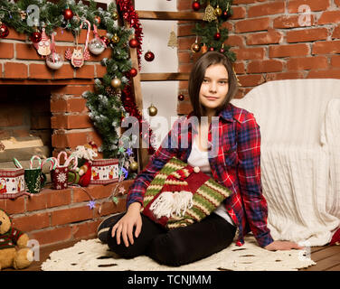 Teenag Mädchen das Lesen eines Buches in der Nähe der Feuerstelle mit Weihnachtsschmuck. Stockfoto