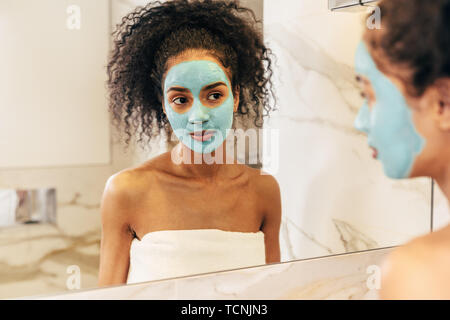 Porträt einer Frau in weiß Handtuch mit natürliche Maske auf Gesicht gewickelt Stockfoto