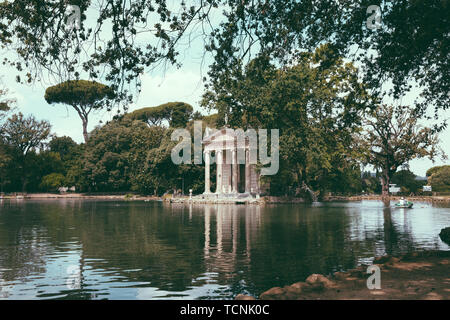 Panoramablick auf den Tempel des Asklepios (Tempio di Esculapio) und See in den öffentlichen Park der Villa Borghese. Tag Sommer und blauer Himmel Stockfoto