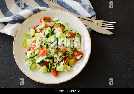 Gesunde Gemüse Salat von frischen Tomaten, Gurken, Peking Kohl und Schnittlauch auf einem Teller. Diät Menü zum Mittagessen. Vegetarische Salat. Ansicht von oben. Stockfoto