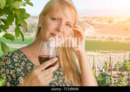 Schöne junge Frau mit einem Glas Wein Weinprobe im Weinberg. Stockfoto