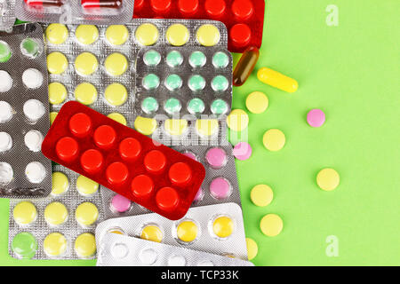 Kapseln und Tabletten in Blistern auf grünem Hintergrund verpackt Stockfoto