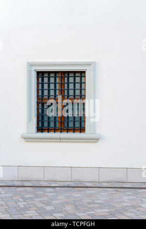 Im städtischen Hintergrund. Weiße Wand mit kleinem Fenster und Eisen Gitter Stockfoto