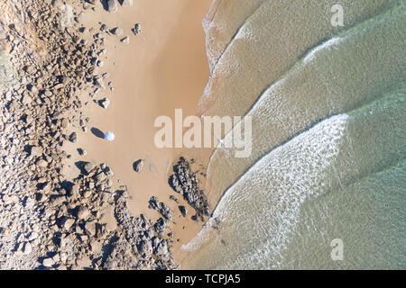 Top schönes Blick auf einen Strand bei Sonnenaufgang mit schönen Wellen Linien, seichten türkisblauen Wasser in ein tropisches Urlaubsziel Stockfoto