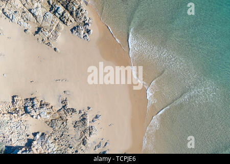 Top schönes Blick auf einen Strand bei Sonnenaufgang mit schönen Wellen Linien, seichten türkisblauen Wasser in ein tropisches Urlaubsziel Stockfoto