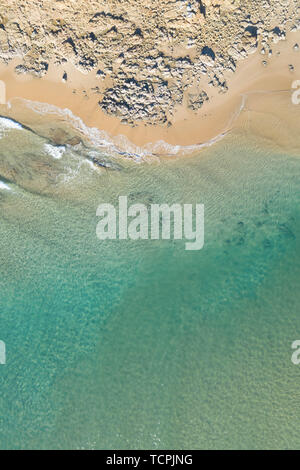 Top schönes Blick auf einen Strand bei Sonnenaufgang mit schönen Wellen Linien, seichten türkisblauen Wasser in ein tropisches Urlaubsziel Stockfoto
