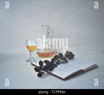 Orangenlikör Alkohol trinken. Kleine Kanne und winzige Wineglass. Gelbe schuss Sanddorn coctail. Notebook Datum Termin Stockfoto