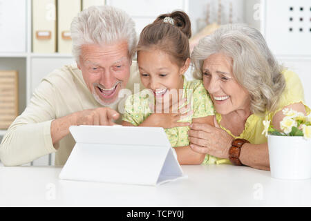 Portrait der Großeltern mit ihrer Enkelin mit Tablet Stockfoto