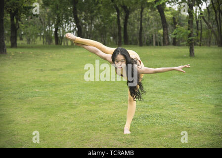 Asiatische junge Frau Yoga auf der park Gras Stockfoto