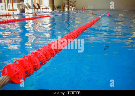 Die rot markierten Fahrstreifen für die Vorbereitung der Schwimmwettbewerbe. Lap Pool mit markierten Wege. Leeren Pool ohne Menschen mit ruhigen stehendes Wasser Stockfoto